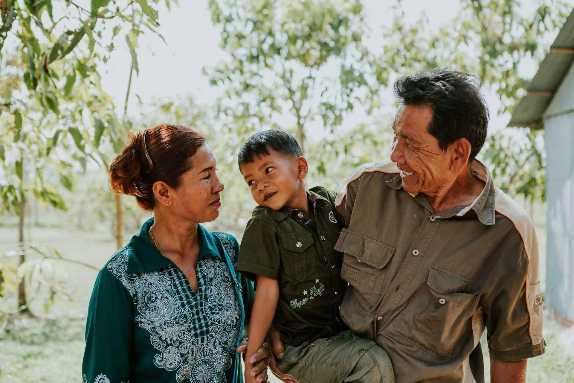 A mother and father look lovingly at their foster child in Cambodia