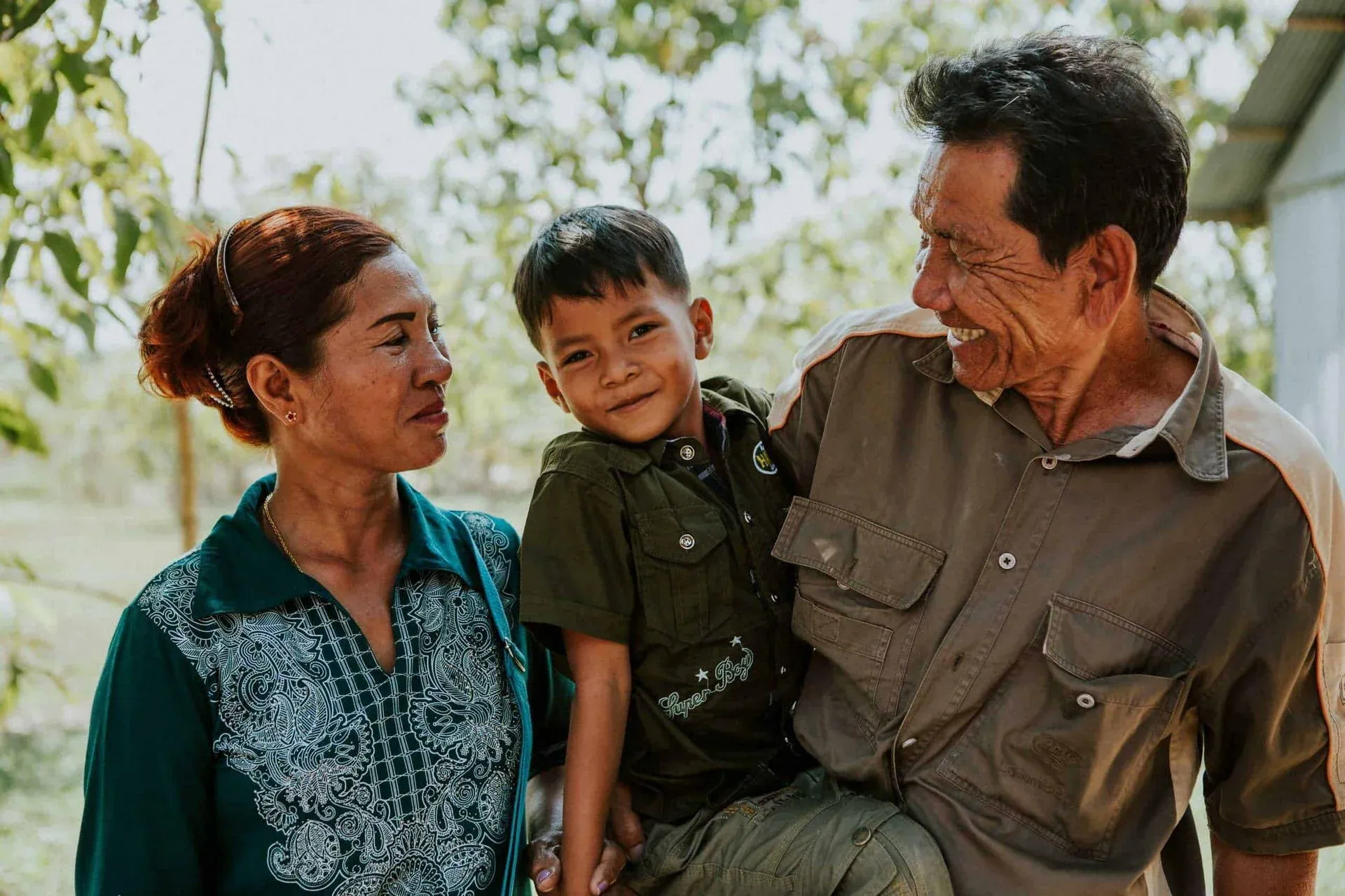 Children in Families Foster parents look lovingly at their foster son as he looks at the camera